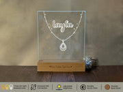 a clear acrylic display with a necklace on it