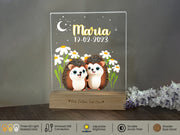 a couple of hedgehogs sitting on top of a wooden stand