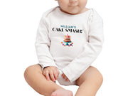 a baby sitting on the floor with a cake on it