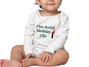 a baby sitting on the floor wearing a onesie