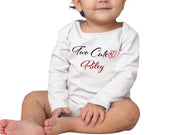 a baby sitting on the ground wearing a white shirt