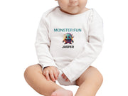 a baby sitting on the ground wearing a white shirt