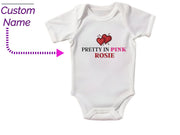 a white bodysuit with a pink rose on it