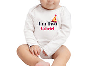 a baby sitting on the ground wearing a hat