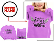 a woman wearing a purple shirt with angel wings on it