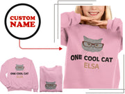 a girl wearing a pink shirt with a cat on it