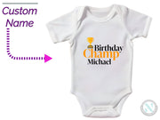 a baby bodysuit with a name and a picture of a trophy