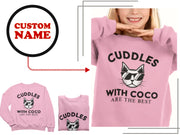 a woman wearing a pink sweater with a cat on it