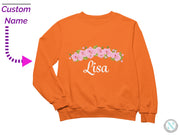 an orange sweatshirt with pink flowers on it