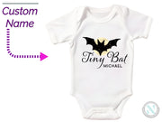 a white baby bodysuit with a bat on it