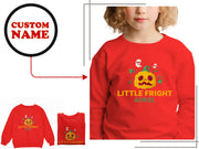 a little girl wearing a red shirt with a pumpkin on it