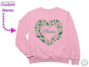 a pink sweatshirt with a green heart and name