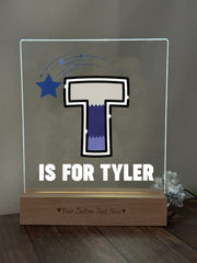 a glass block with a picture of a t is for tyler